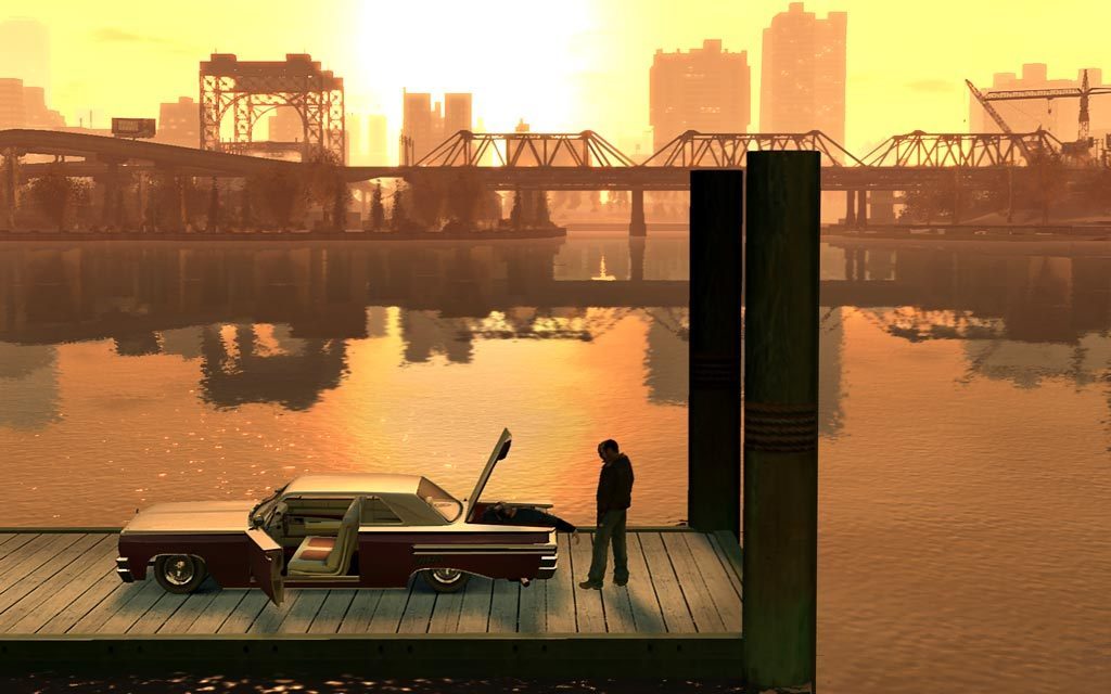 A man standing beside a car on a Liberty City dock at sunset in GTA IV